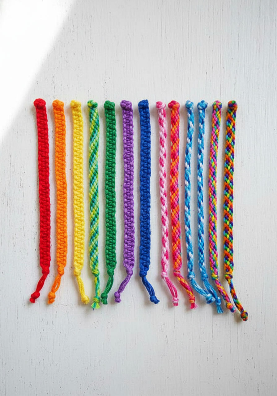Finished cardboard loom friendship bracelets in rainbow colors showing spiral woven pattern and adjustable closures