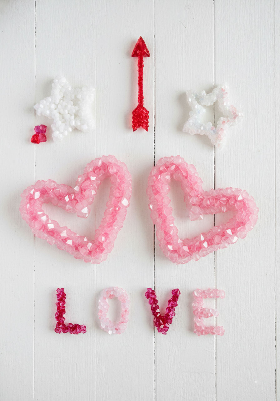 Various shaped borax crystals including hearts, stars, arrow, and LOVE letters showing different Valentine's Day crystal growing project ideas