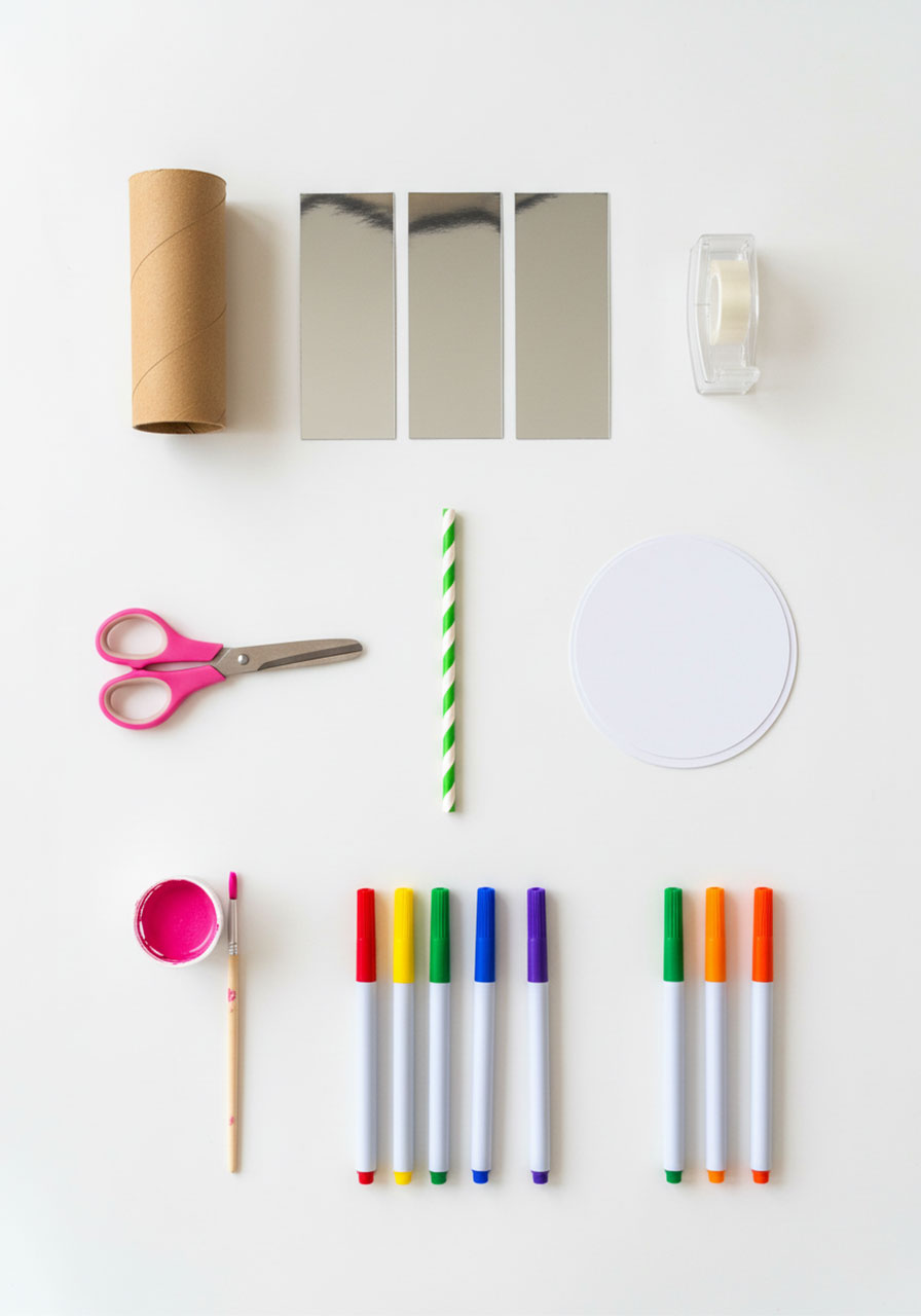 Materials needed to make DIY kaleidoscope including toilet paper roll, mylar sheets, straw, cardstock, and markers