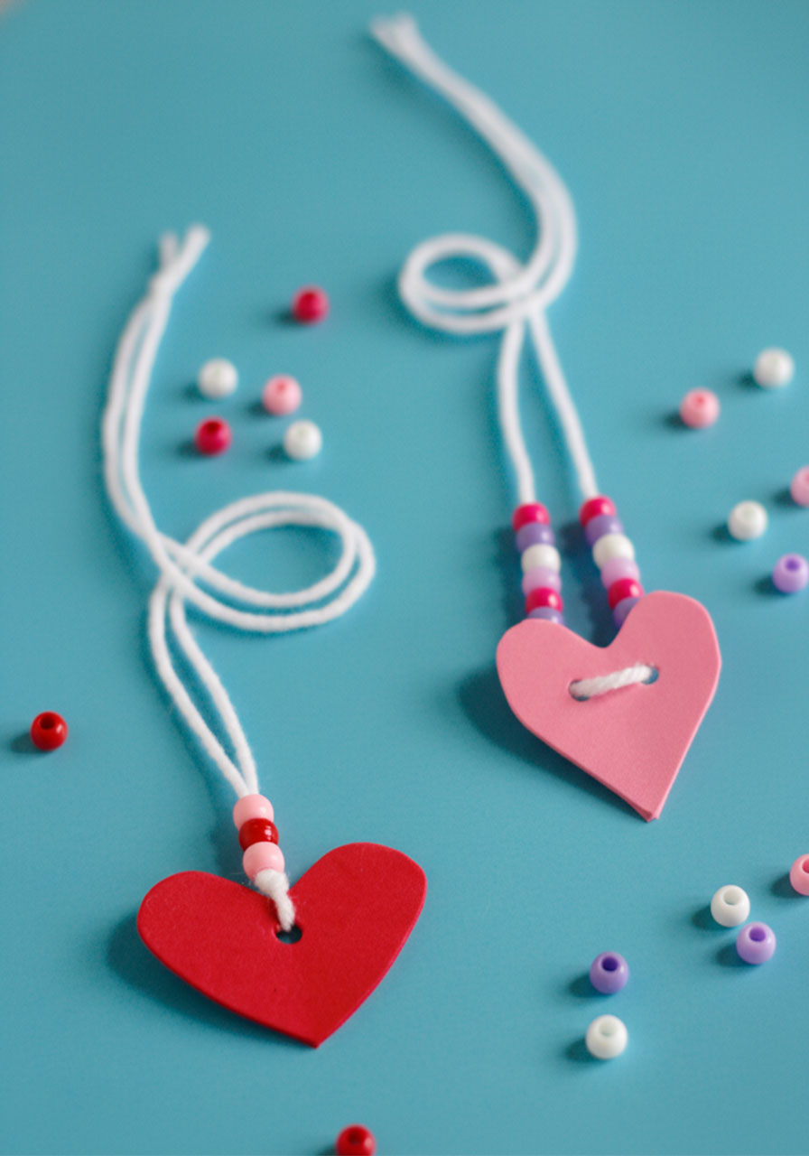 DIY Valentine's friendship necklaces with red and pink foam hearts and colorful beaded strings for kids classroom exchange