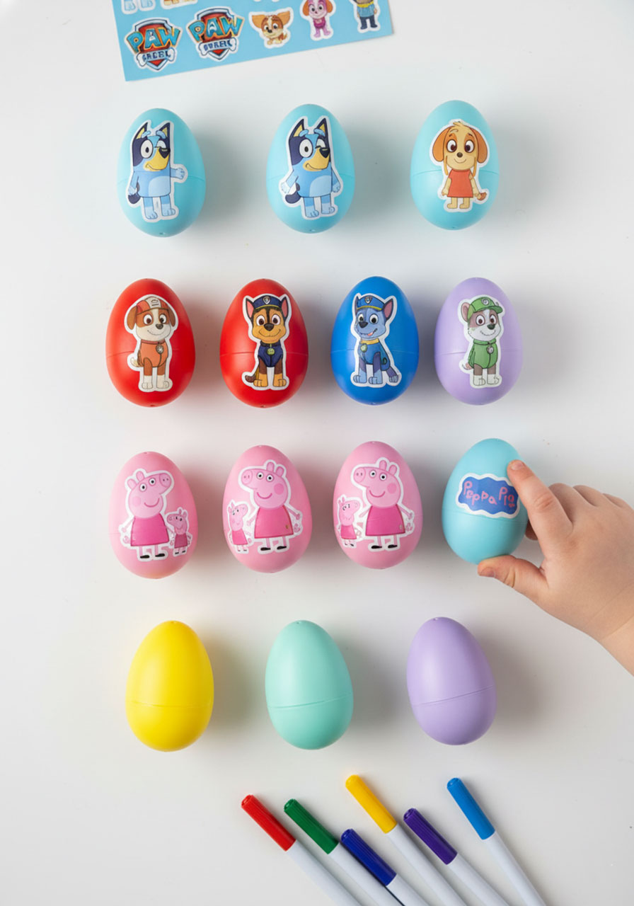 Easter eggs decorated with popular toddler character stickers including Bluey, Paw Patrol, and Peppa Pig for themed egg hunt