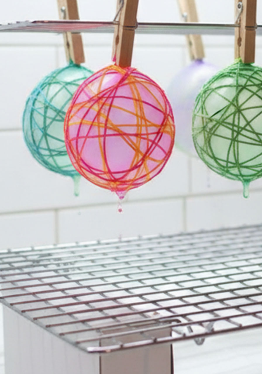 Drying rack setup for string Easter eggs showing balloons clipped with clothespins and proper spacing