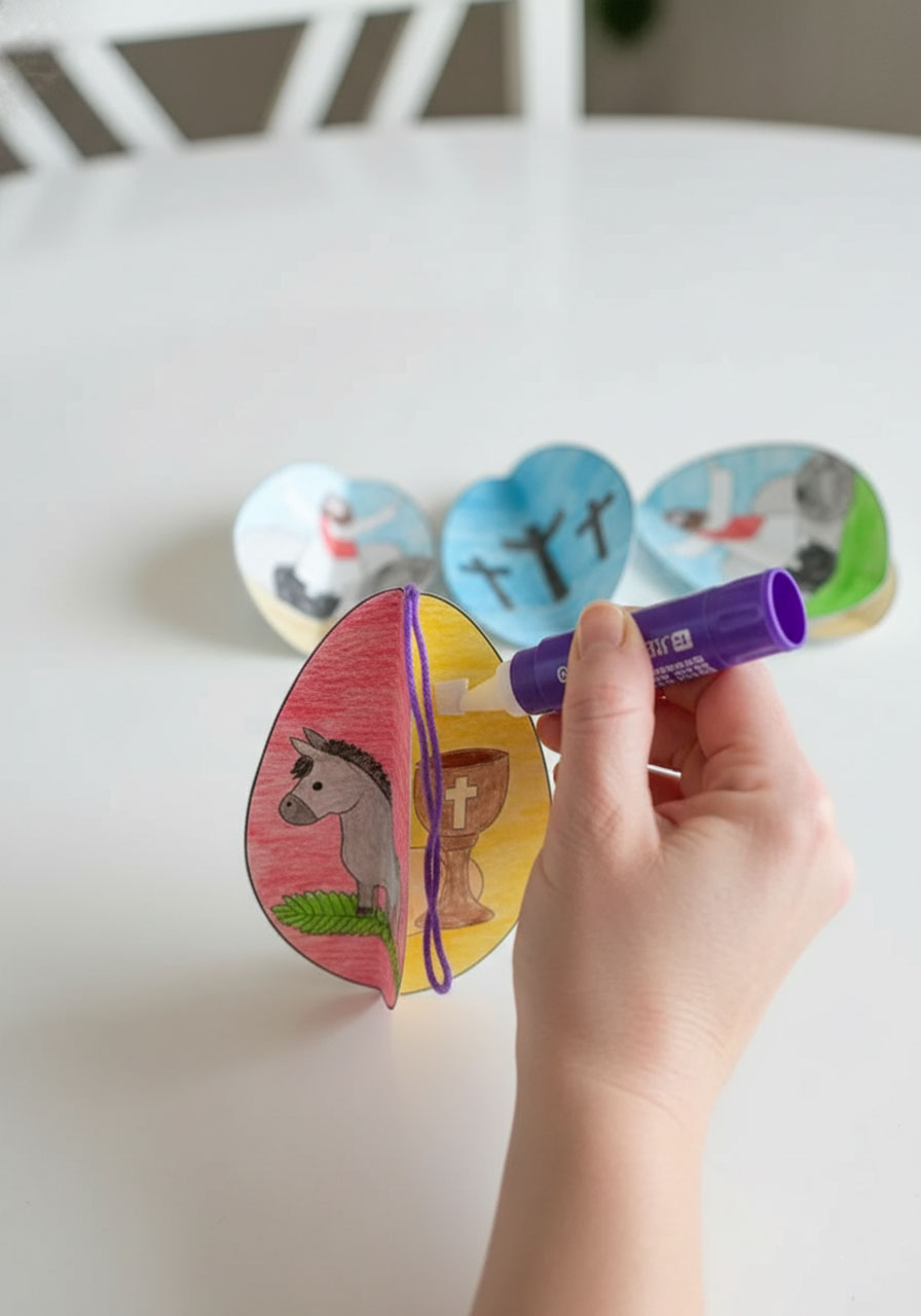 Gluing two Easter egg panels back-to-back with yarn hanger between them for 3D assembly