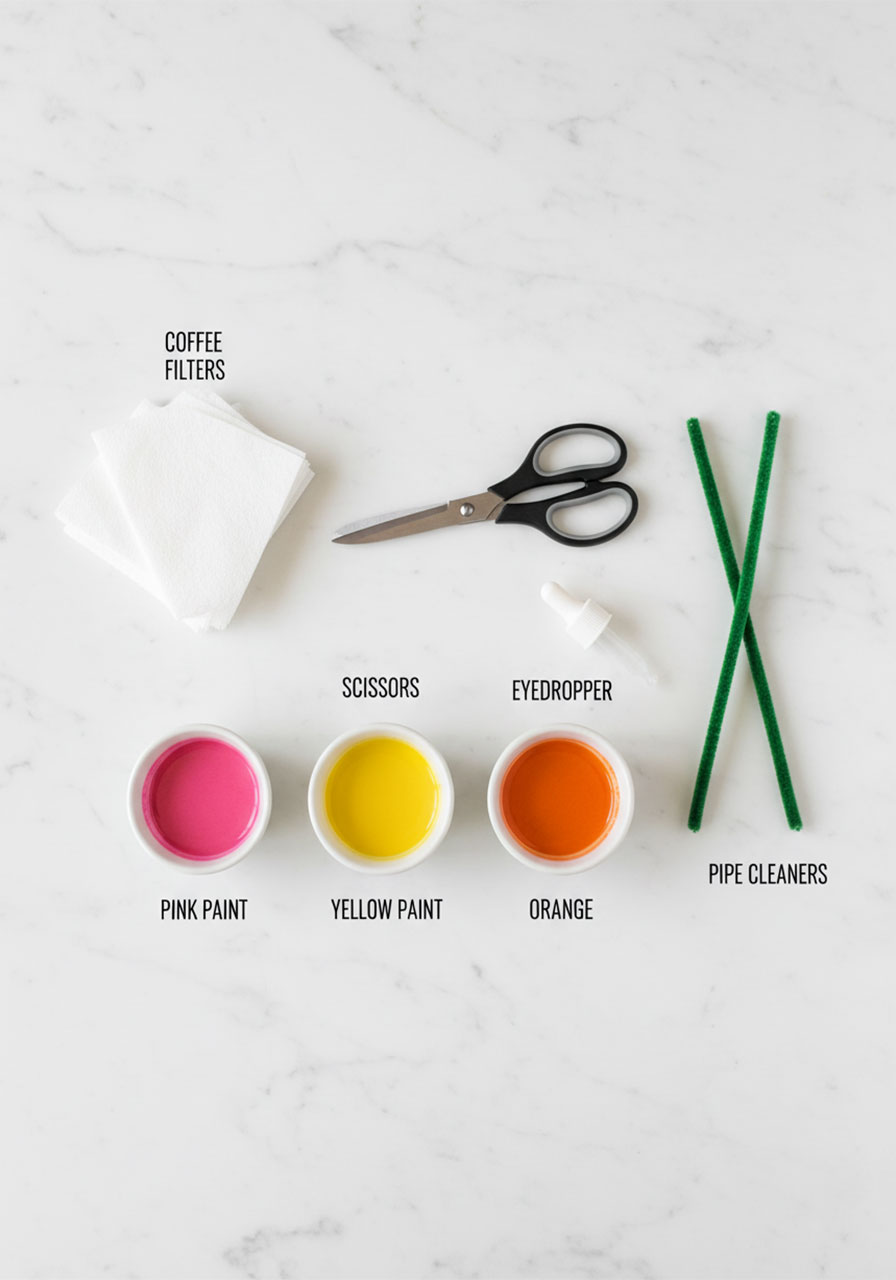 All supplies needed for easy coffee filter flower Mother's Day craft including pipe cleaners, watercolor paint, and coffee filters