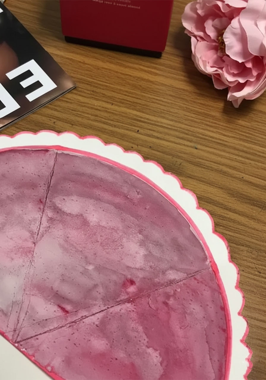 White cardstock semi-circle being cut with scissors and folded into a cone bouquet wrapper for a DIY Mother's Day tulip card step2b