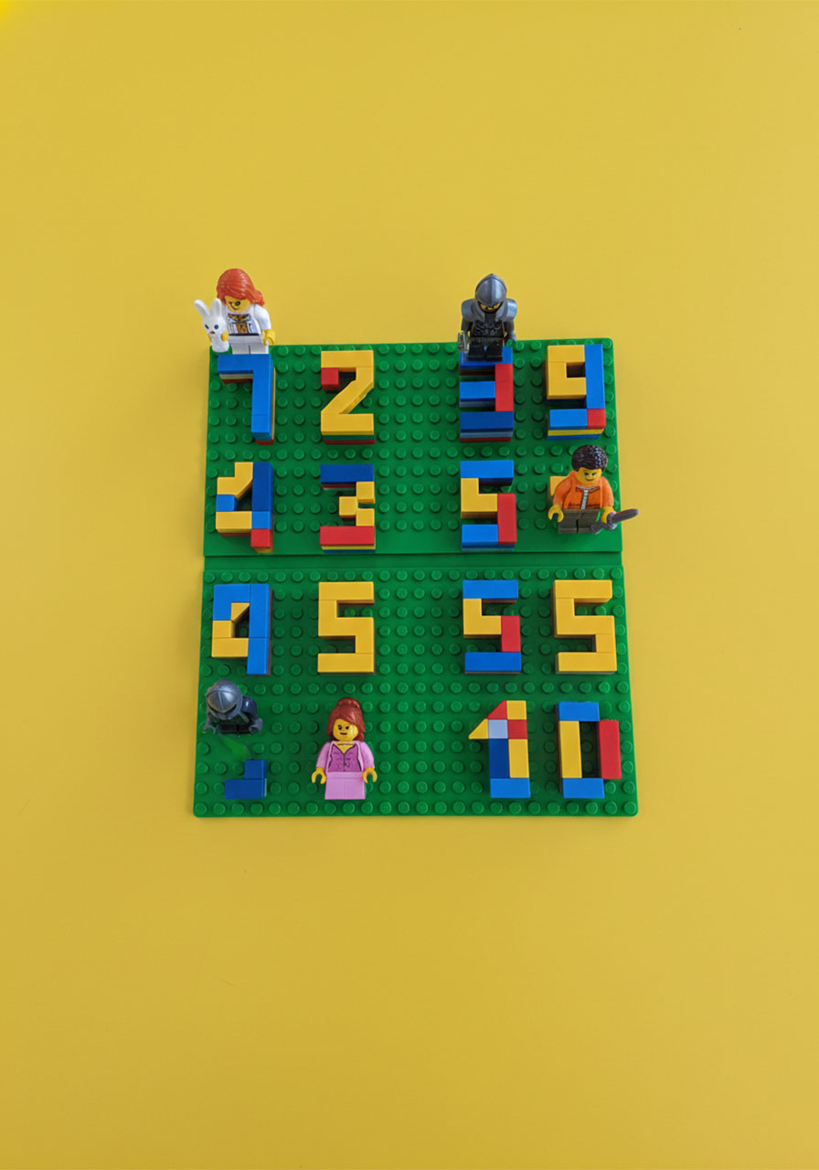 DIY LEGO scoreboard made from colorful bricks numbered 1 to 10 with four unique LEGO minifigure player tokens