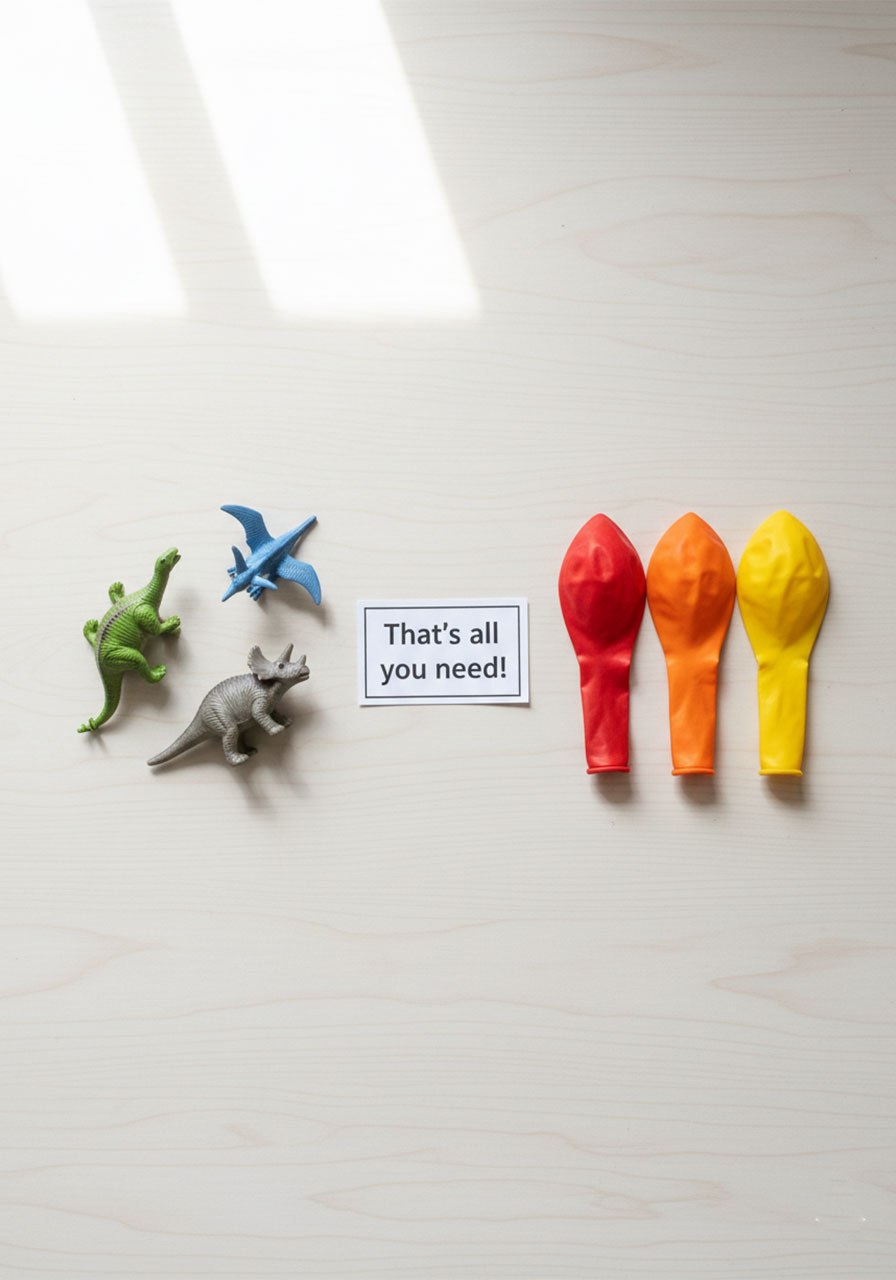 Flat lay of only two supplies needed – small plastic dinosaurs and colorful balloons – for making frozen dinosaur eggs