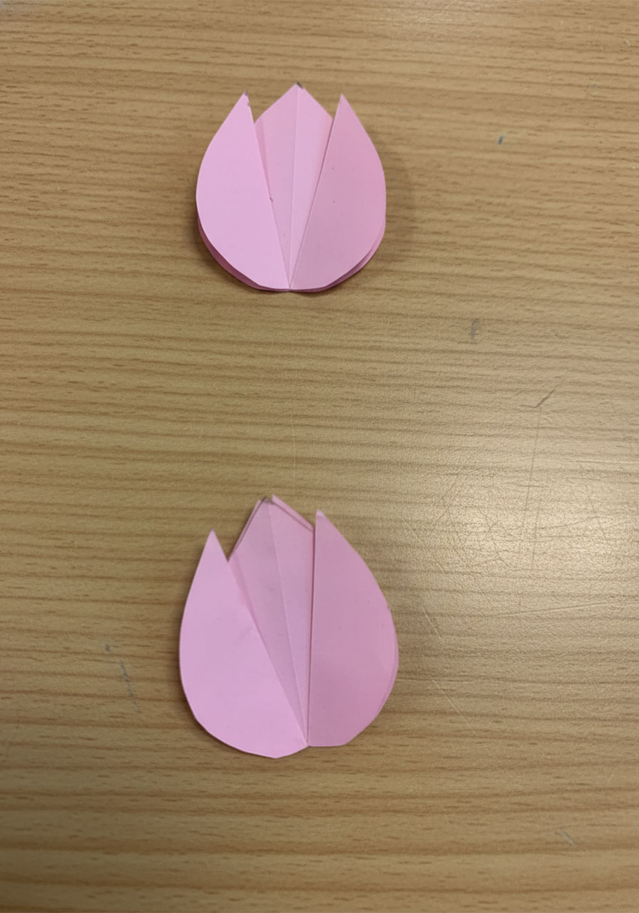 Step-by-step flat lay showing how to fold a 3D paper tulip for a DIY Mother's Day bouquet card, five stages from flat square to finished flower step1m