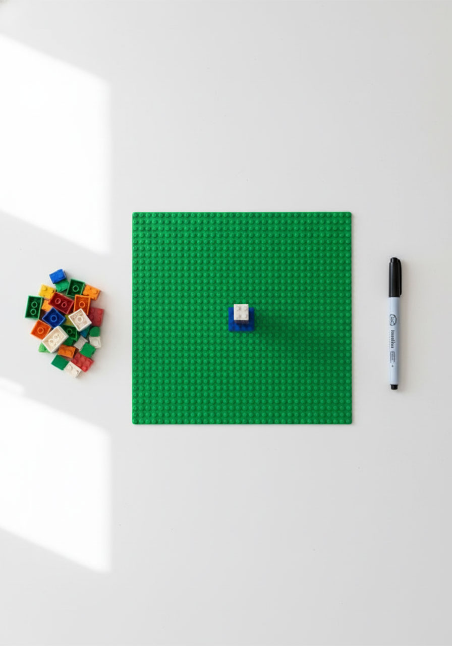 Materials needed for DIY LEGO sundial: LEGO baseplate, assorted 2x2 bricks, and dry-erase marker on white table