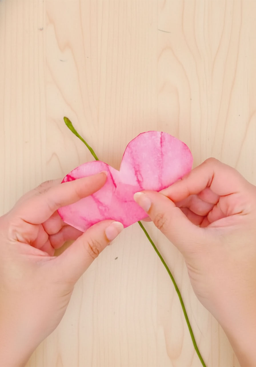 Rolling the first coffee filter petal section tightly around the floral wire stem with a hot glue gun to form the rose center bud step6a