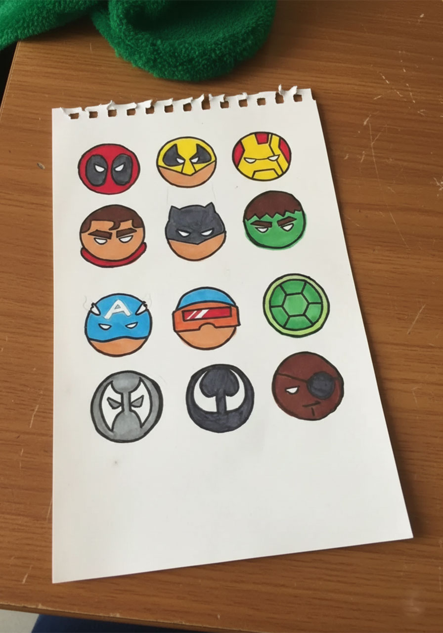 Completed and fully colored superhero face circle cutouts made with markers for a DIY Father's Day pop-up card	phase 1 step2b
