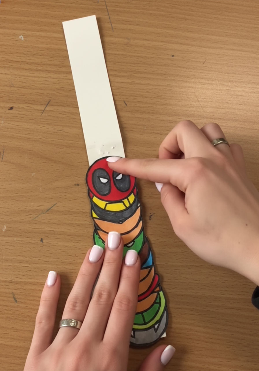 Completed accordion strip with all superhero circles attached showing the full hero tower before card assembly