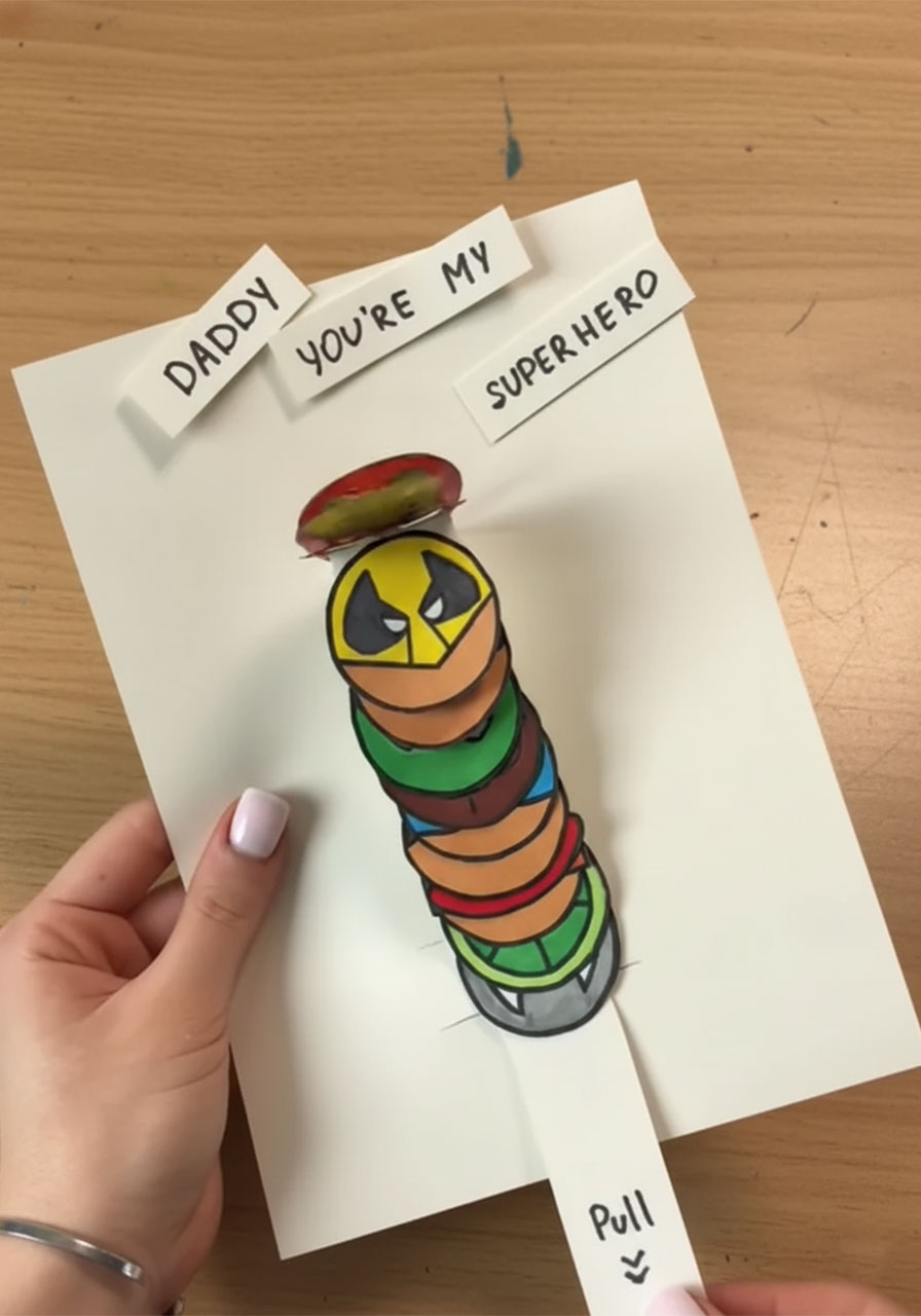 Finished DIY pop-up superhero card for Father's Day with hero accordion tower and pull tab