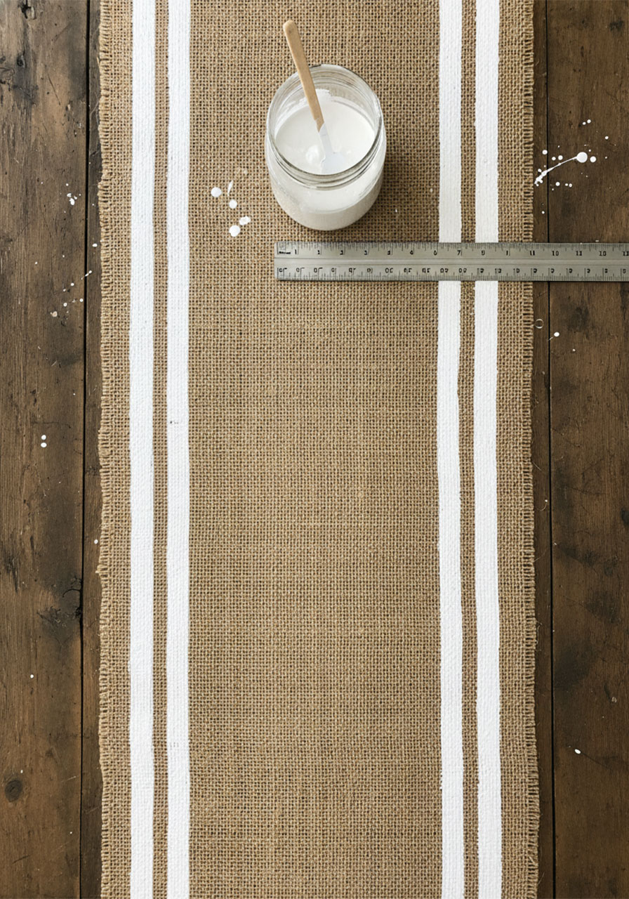 DIY striped burlap table runner with painted white stripes for a rustic-chic tea party.