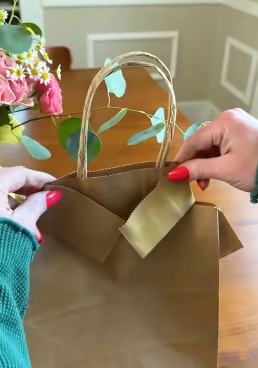 Using a tape runner to secure the paper collar flaps on a DIY shirt and tie Father's Day gift bag step5b