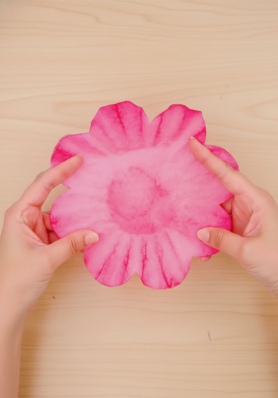 Applying red liquid watercolor paint to coffee filters draped over a glass to create beautiful ombre blush pink rose petals step3d