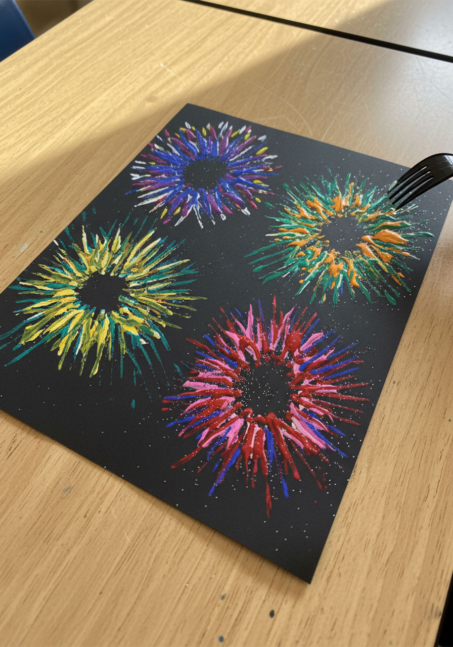 Rainbow color variation of fork painted fireworks craft for kids on black cardstock with multi-colored paint and glitter