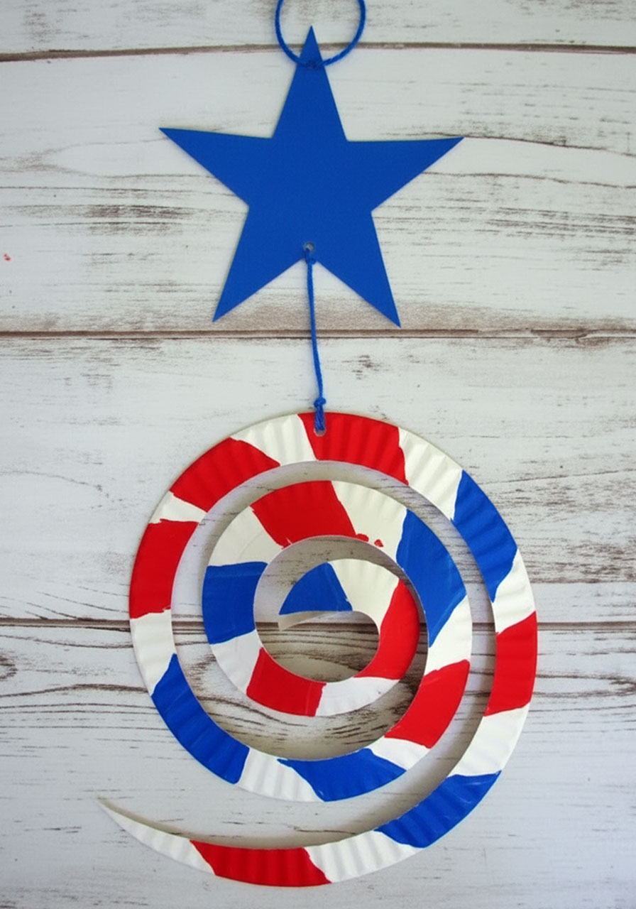 Fully assembled patriotic paper plate wind catcher showing blue star connected to red white striped spiral before hanging