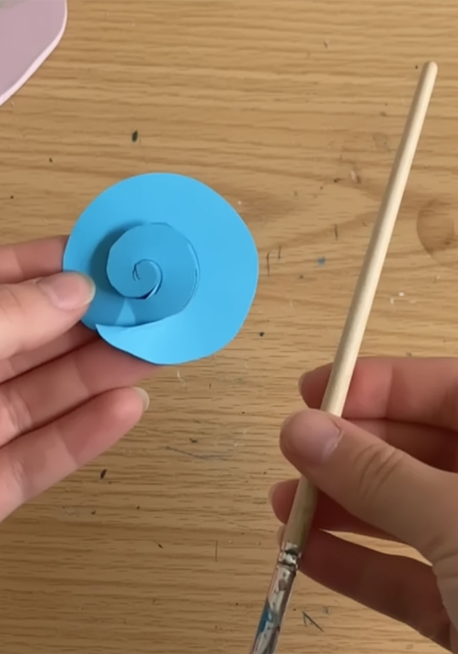 Single completed 3D spiral paper rose made from blue cardstock — close-up of finished paper rose for DIY Father's Day bouquet part 1