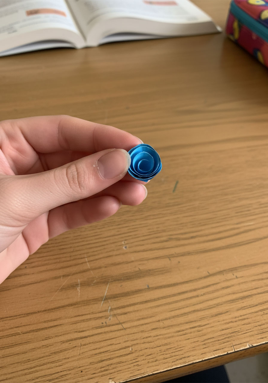 Single completed 3D spiral paper rose made from blue cardstock — close-up of finished paper rose for DIY Father's Day bouquet part 3
