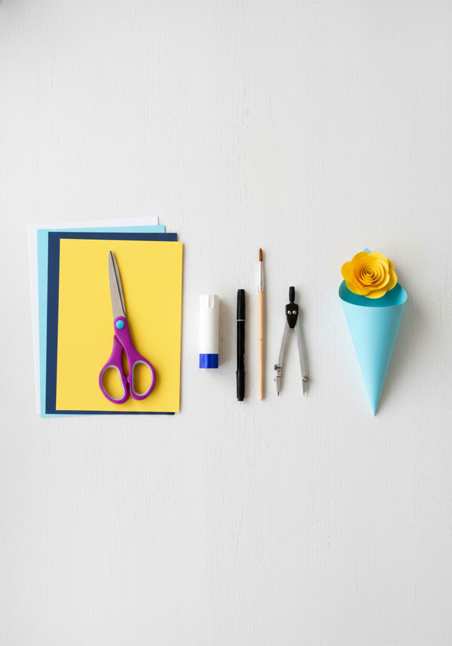 Craft supplies needed for DIY paper rose heart bouquet — cardstock, scissors, glue stick, thin stick, and markers laid out flat