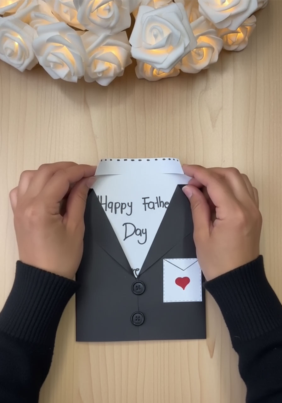 Gluing black paper bow tie onto white shirt insert for DIY tuxedo Father's Day card step 4a