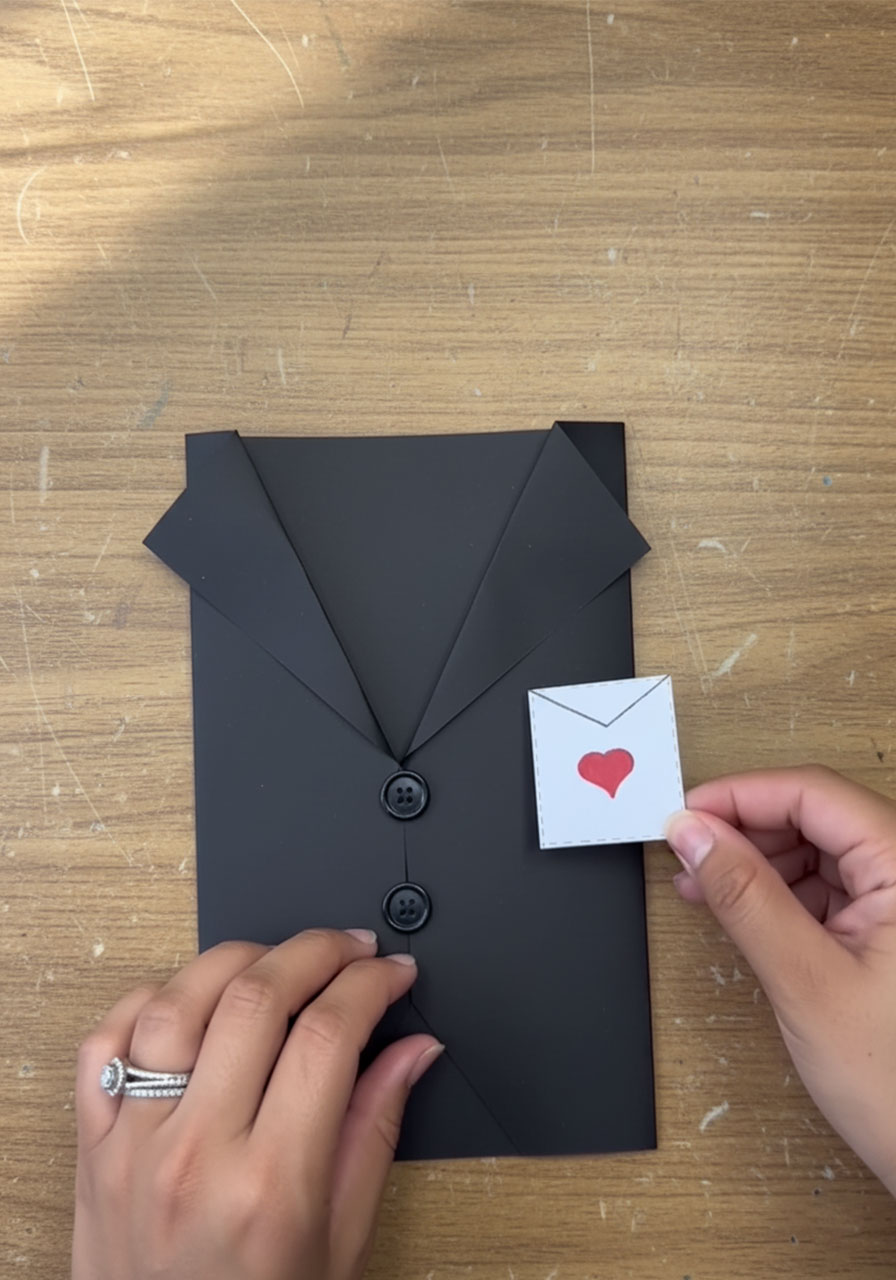 Close-up of tiny white paper pocket square with red heart glued to DIY tuxedo Father's Day card chest