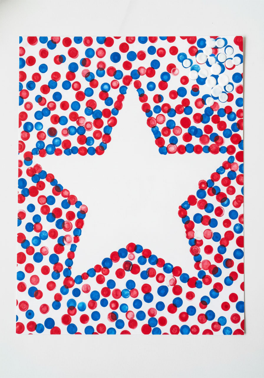 Close-up of a completed Memorial Day star fingerprint craft showing crisp white star silhouette surrounded by red and blue fingerprint dots on white cardstock