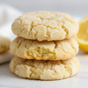 Close-up macro shot of stacked gluten-free lemon crinkle cookies showing the soft chewy interior and powdered sugar crinkle crack texture on top