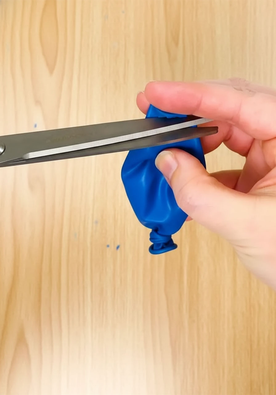 Three-step process showing how to tie cut and stretch a red balloon over a toilet paper roll to make a DIY confetti popper step 1&2b