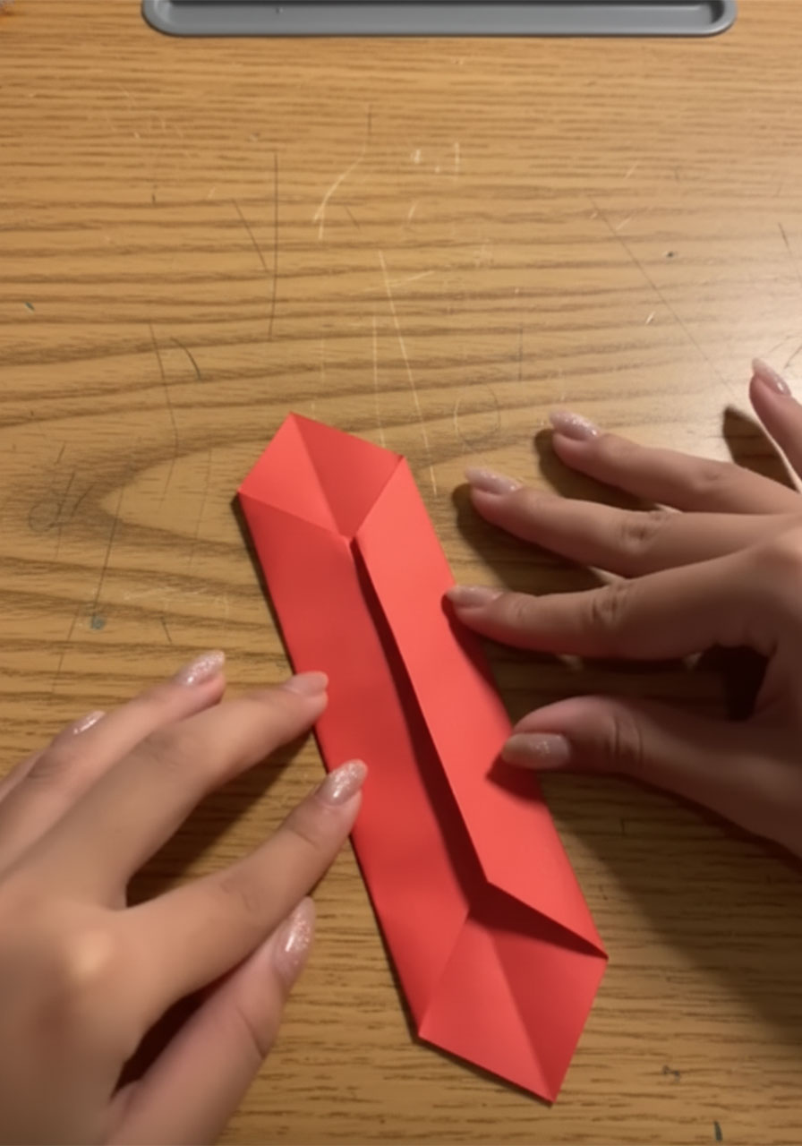 Three stages of folding a red origami necktiae for a DIY Father's Day suit-and-tie card, from flat paper to completed 3D tie with knot step3b
