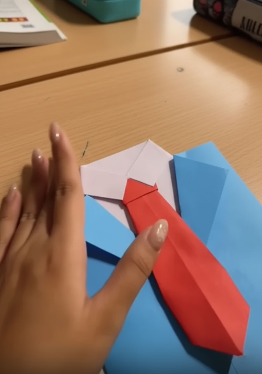 Three stages of folding a red origami necktiae for a DIY Father's Day suit-and-tie card, from flat paper to completed 3D tie with knot step3e