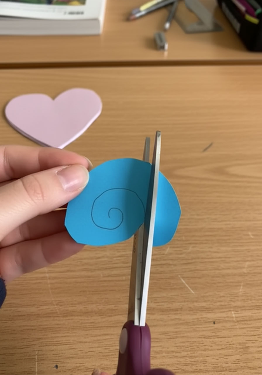 Hands rolling a cut paper spiral strip around a thin stick to form a 3D paper rose — DIY paper rose bouquet tutorial step by step 2b