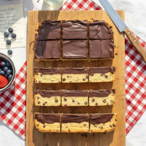A full batch of sliced sugar free low carb cookie bars showing clean layers of almond flour cookie dough and dark chocolate ganache