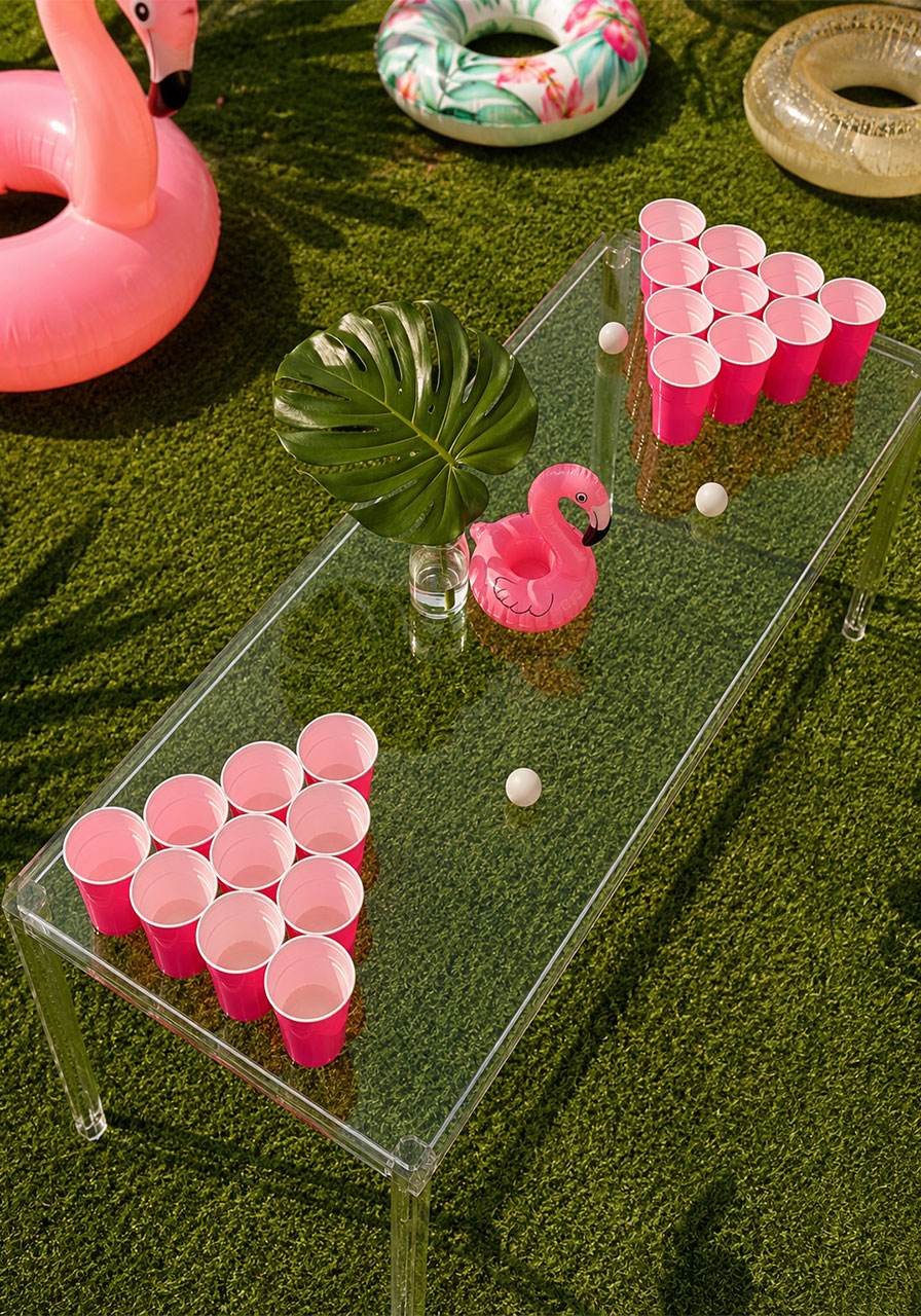 Overhead view of pink cup beer pong table setup on acrylic table for 21st birthday party outdoors