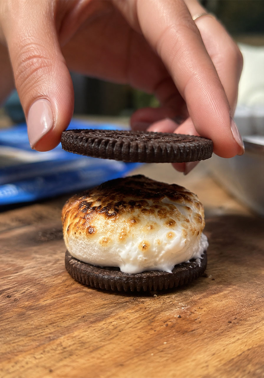 Sandwiching a toasted marshmallow between Oreo cookie halves