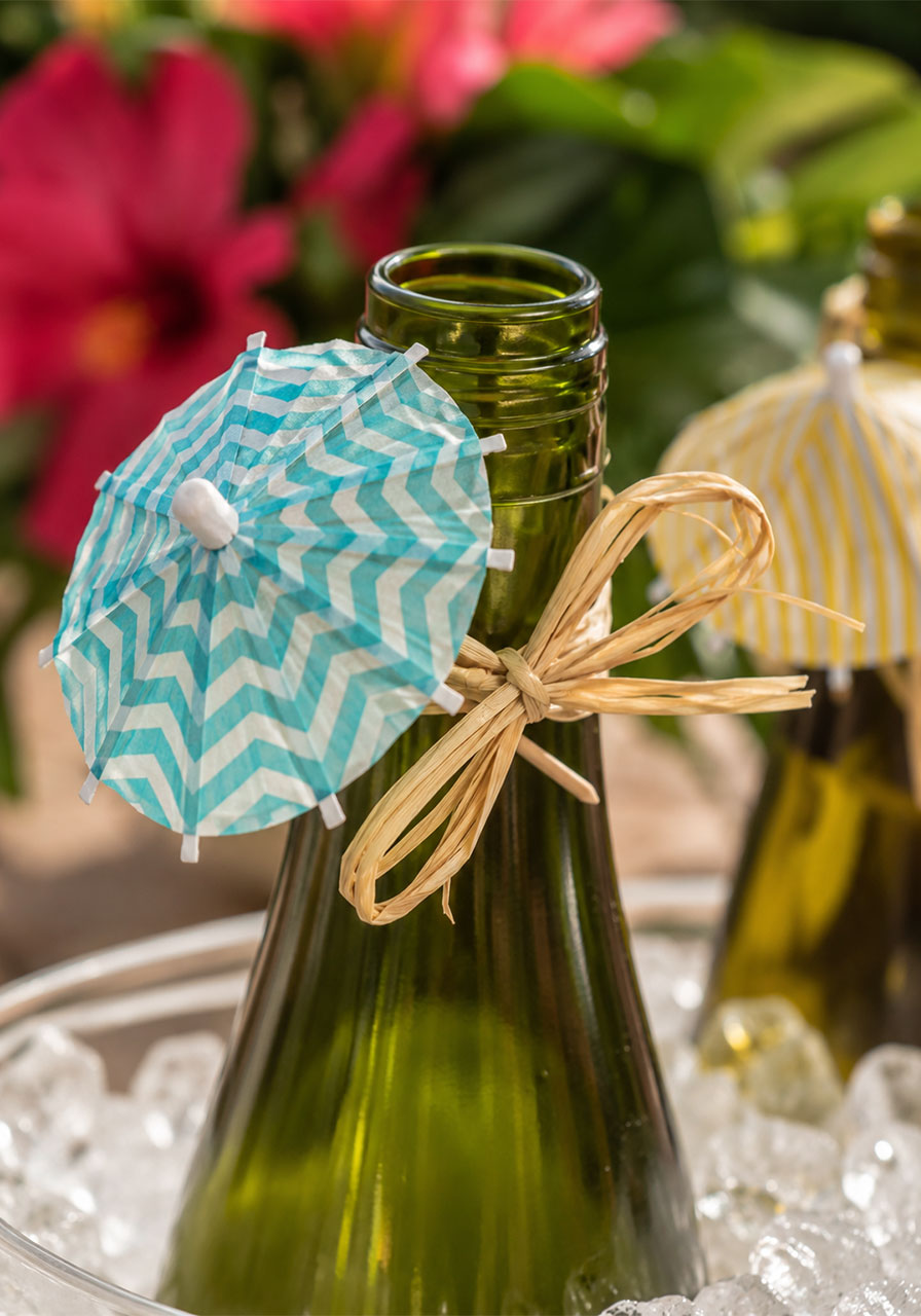 Mini cocktail umbrella tied with raffia on a wine bottle as a fun Key West party drink decoration detail