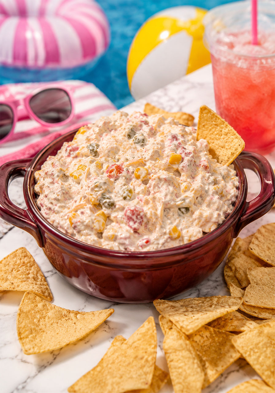 Creamy TikTok boat dip in a red ceramic bowl surrounded by tortilla chips
