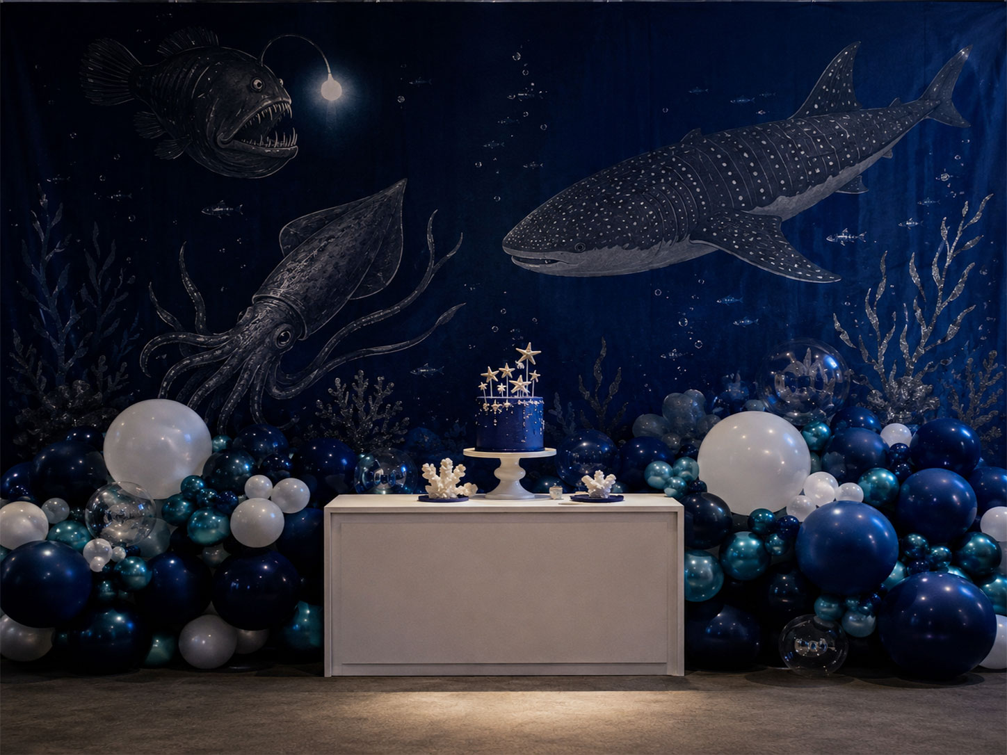 Dramatic deep sea navy backdrop with sea creature silhouettes for an under the sea birthday party