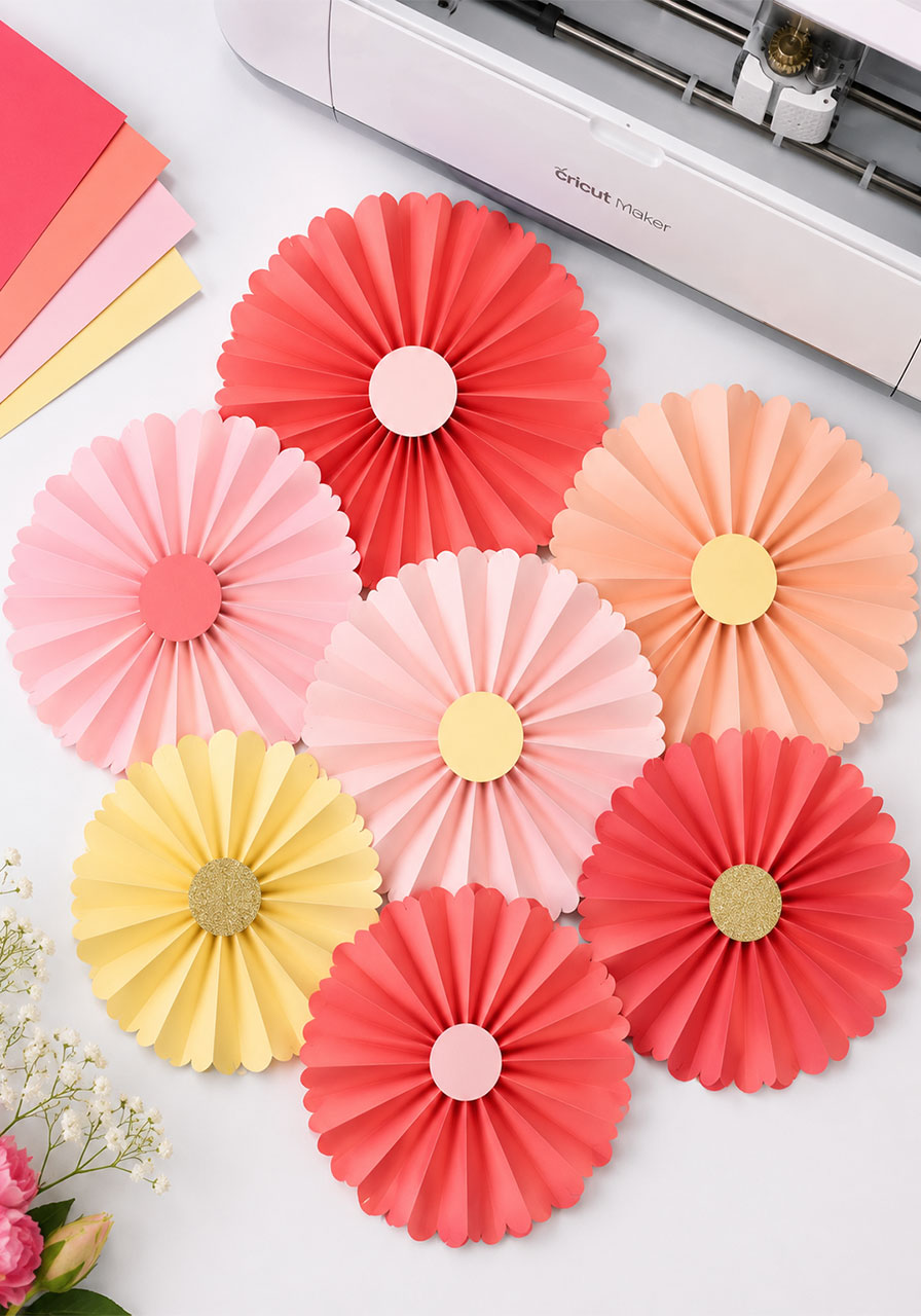 DIY paper rosettes made with Cricut Scoring Wheel in coral, pink and yellow for bridal shower decorations