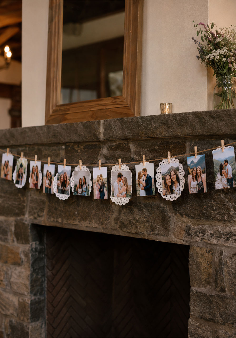 DIY photo banner with couple photos clipped to jute twine on rustic stone mantle – at-home bridal shower decoration