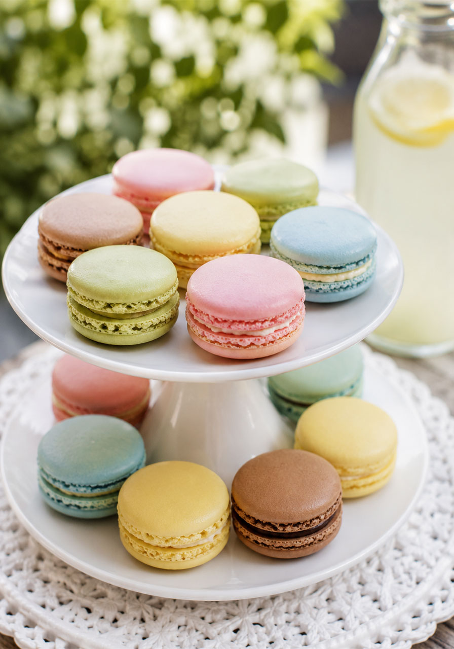 Colorful French macarons stacked on a tiered stand for a tea party dessert display