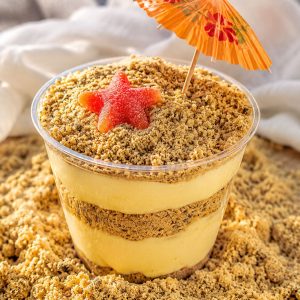 Golden Oreo Sand Pudding served in a clear cup with a paper umbrella and gummy starfish