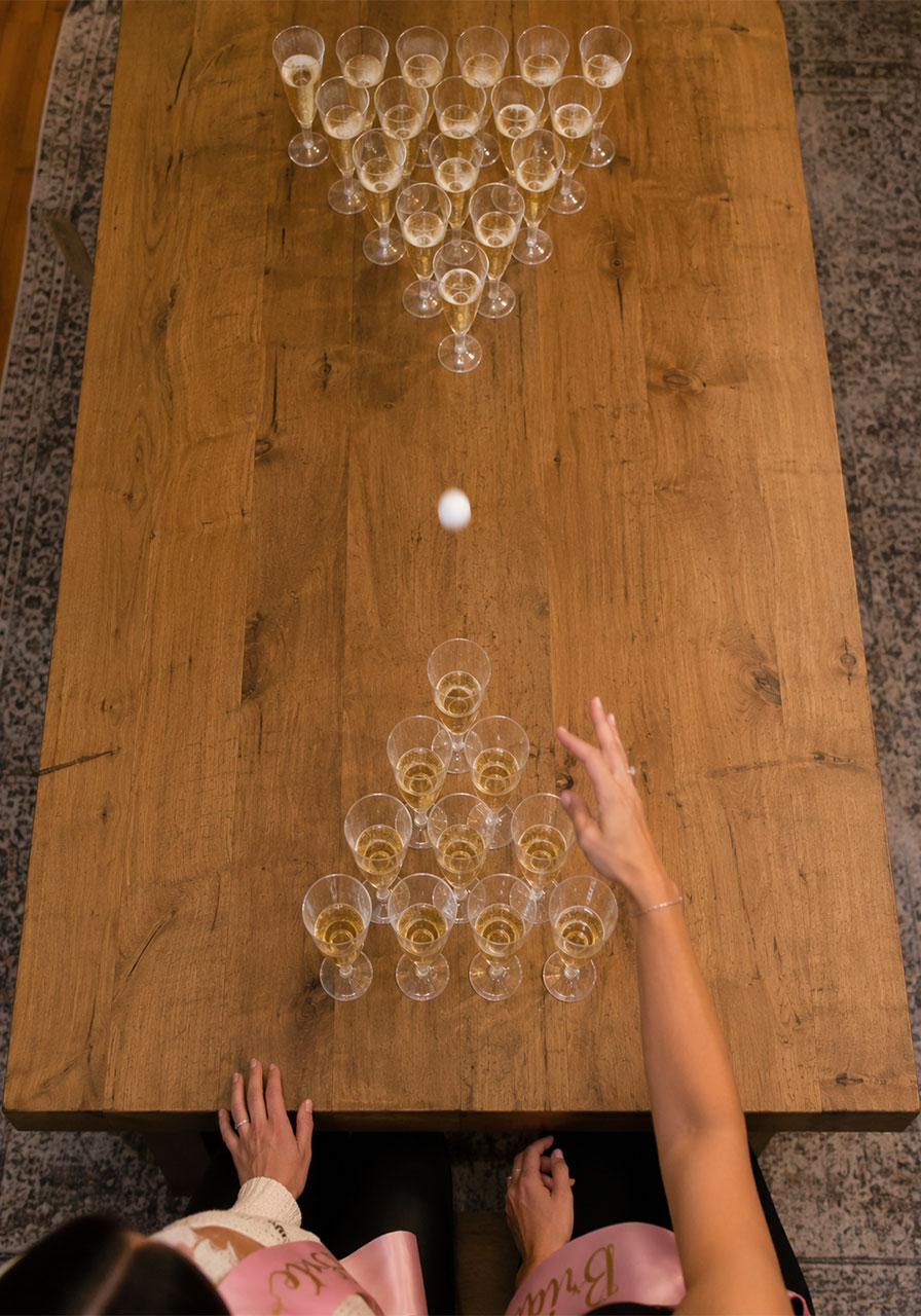 Champagne pong setup with sparkling wine flutes, a fun bachelorette drinking game
