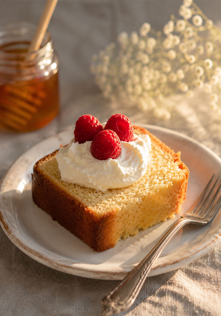 Honey tea cake slice served with whipped cream and fresh berries for a party dessert