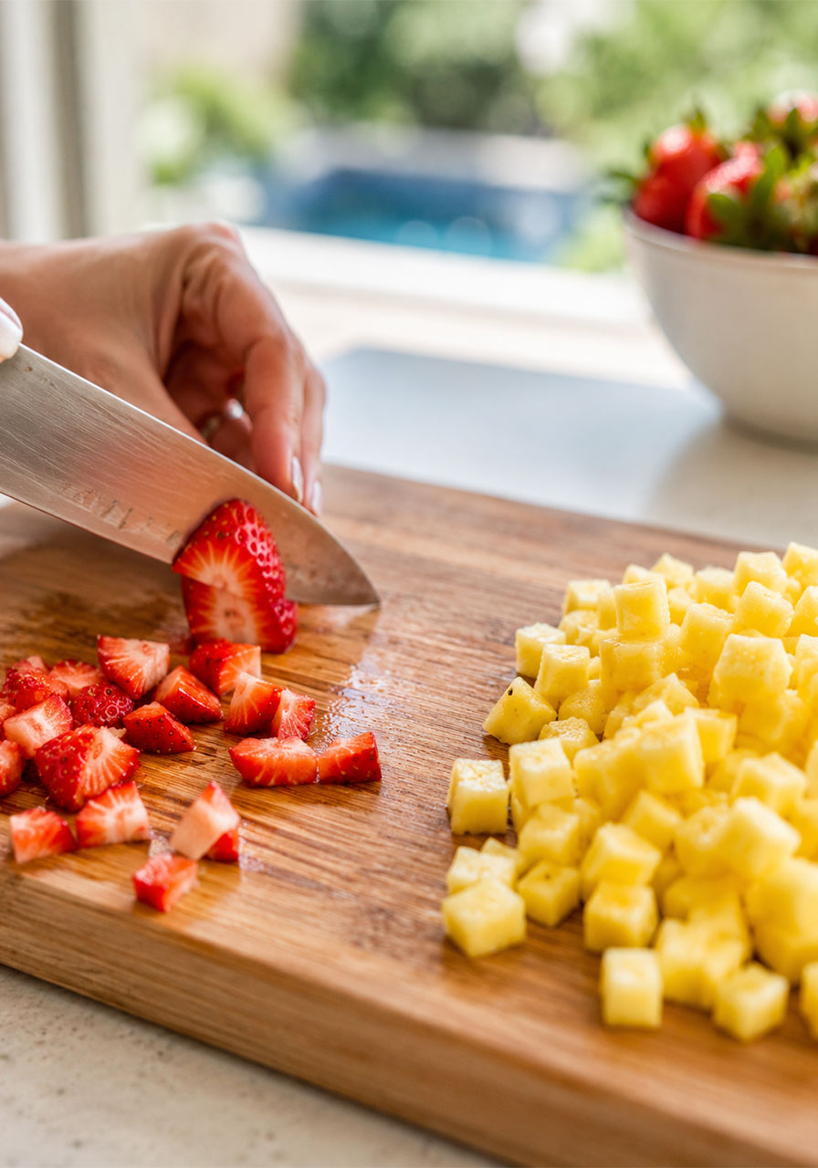 Dicing fresh strawberries and pineapple into uniform small pieces for homemade strawberry pineapple salsa