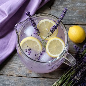 Overhead view of lavender tea lemonade pitcher garnished with lemon slices and fresh lavender sprigs