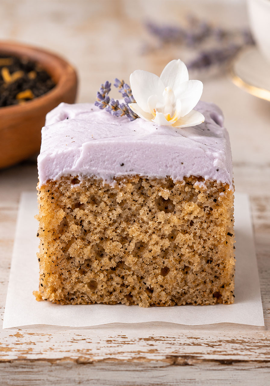 Close-up of London Fog cake slice showing moist Earl Grey crumb and lavender cream cheese frosting
