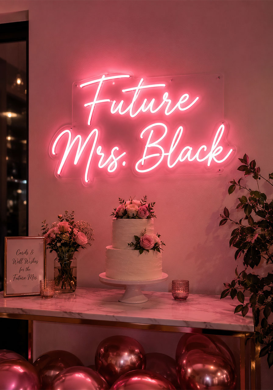Glowing pink LED neon Future Mrs sign mounted above cake table at indoor bridal shower party