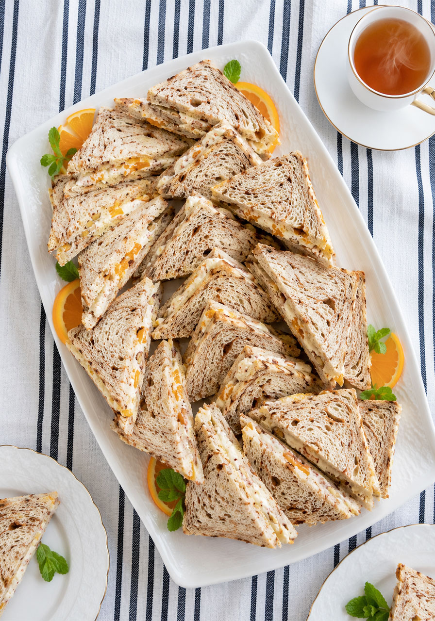 Platter of creamy orange cinnamon tea sandwiches arranged for a tea party or brunch